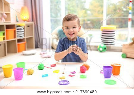 Little boy engaged in playdough modeling at daycare