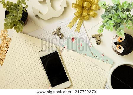 top view vintage of ribbin bow, coffee, phone, paperclip and cactus