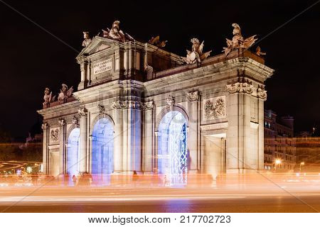 Madrid, Spain - December 8, 2017: Puerta de Alcala in Madrid at night on Christmas time with light trails of traffic