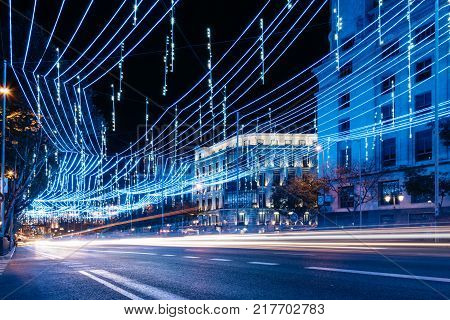 Madrid, Spain - December 8, 2017: Alcala Street in Madrid at night on Christmas time. Long exposure shot with light trails of traffic and blurred people