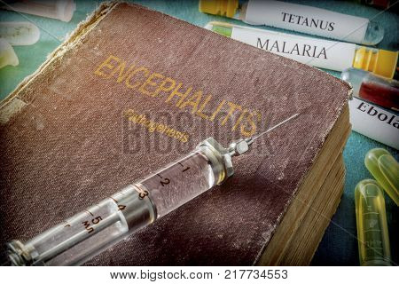 Vintage Syringe On A Book Of encephalitis, Medical Concept