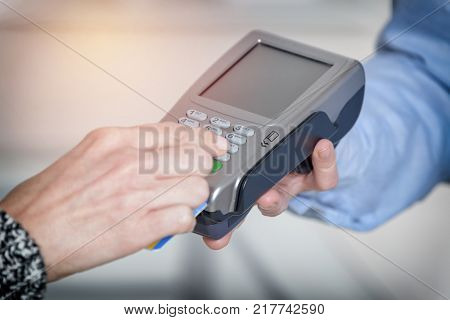 Entering PIN code on wireless payment terminal with inserted redit or debit card