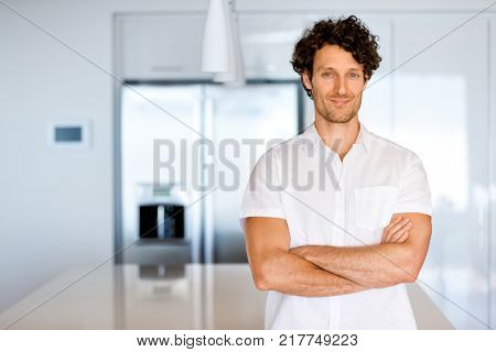 Portrait of a smart young man standing in kitchen