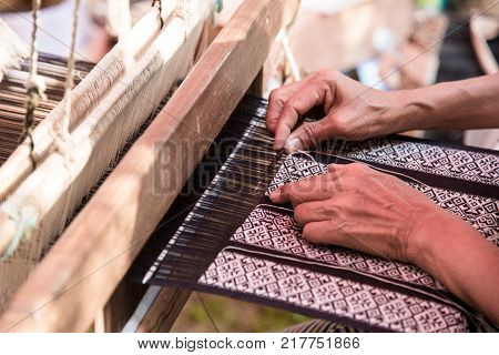 Close up Weavers are weaving with a loom and threading.