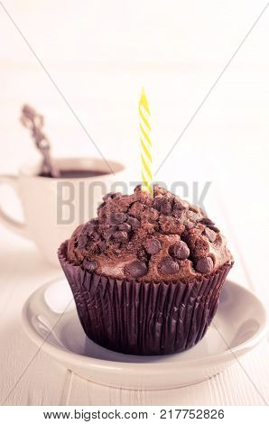 Birthday muffins or capkakes with chocolate and black coffee on a white wooden table. White background. Sweet food. Festive mood copy space flat lay