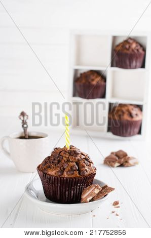 Birthday muffins or capkakes with chocolate and black coffee on a white wooden table. White background. Sweet food. Festive mood copy space flat lay