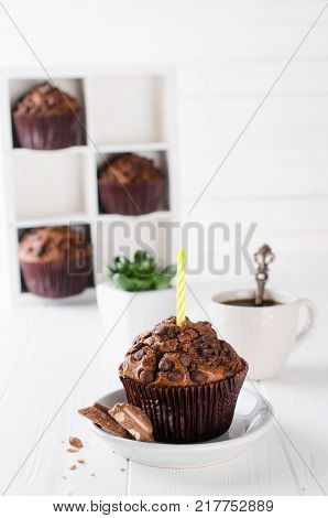 Birthday muffins or capkakes with chocolate and black coffee on a white wooden table. White background. Sweet food. Festive mood copy space flat lay