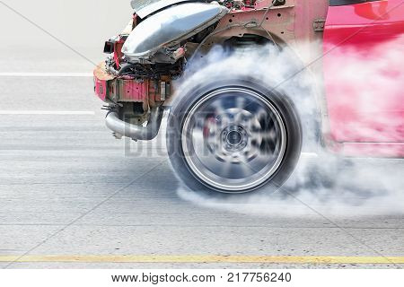 race car burns rubber off its tires in preparation for the race