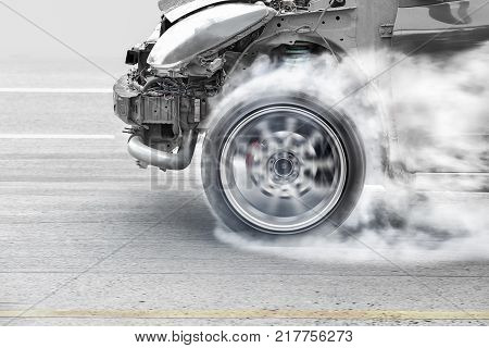 race car burns rubber off its tires in preparation for the race