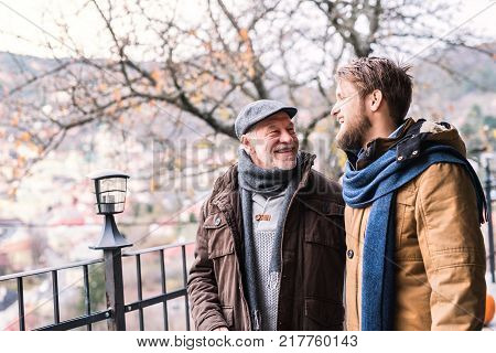 Senior father and his young son on a walk in town.