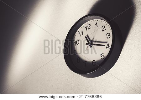 Just a wall watch showing the time in few seconds in black and white abstract composition.