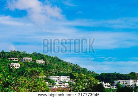Condominiums on the hill. Houses on the mountain among the jungle. Asian nature and city. Cottages in a green forest.