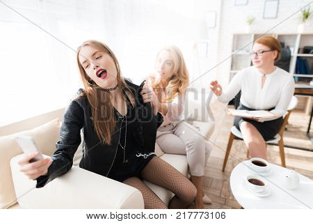 A teenage girl with her mother at a psychologist's reception. The girl has a complicated character. She does not listen to adults. She loves rock music and dressed in a leather jacket.