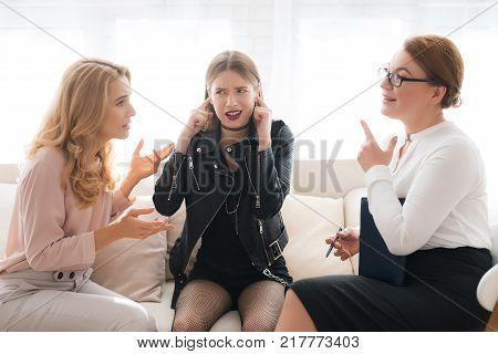 A teenage girl with her mother at a psychologist's reception. The girl has a complicated character. She does not listen to adults. She loves rock music and dressed in a leather jacket.