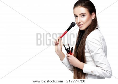 beautiful woman make-up artist with natural make-up holding makeup brush on white background