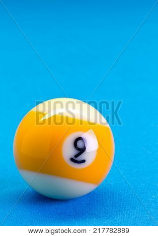 Billiard pool game nine ball on billiard table with blue cloth copy space
