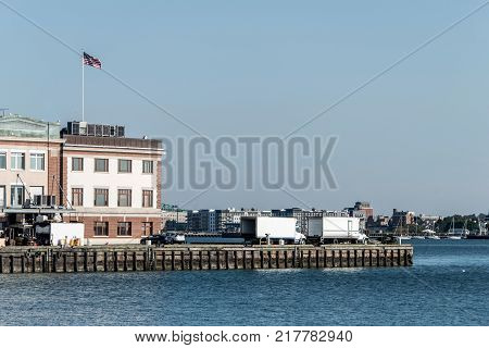 View of harbor from the Boston Waterfront with fishing boat trucks and boats anchored Massachusets USA
