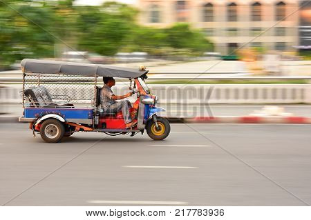 BANGKOK, THAILAND - January 21:A three wheeled Tuk Tuk taxi or three wheel bike on a street in the Thai capital ,which is a famous traditional taxi.on January 21, 2017 in Bangkok, Thailand.