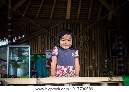 BALI, INDONESIA - DECEMBER 5, 2017: Closeup portrait of cute asian balinese girl outdoors. Bali island, smiling girl.