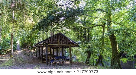 Side view of a shed ready for dining with plastic roof and without walls and the path of access inside a typical Atlantic forest in Galicia Spain