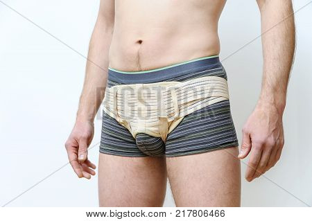 Prevention inguinal hernia. A man is girded with a hernia belt.