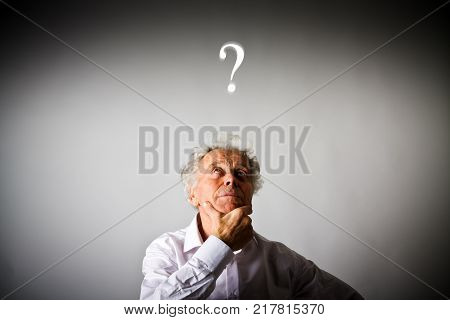 Old man is full of doubts and hesitation. Old man and question mark above head.