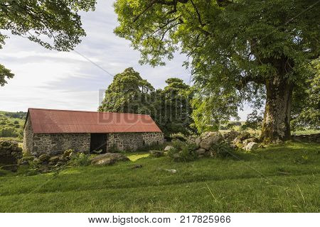 An image of a red roofed barn at Emsworthy Dartmoor Devon. England UK.