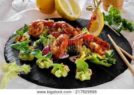 Barbecue grilled prawns with guacamole salad close-up