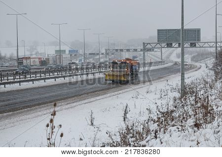 Hemel Hempstead UK - December 10 2017: Snow plough truck spreading salt on the british motorway m1 during snowstorm