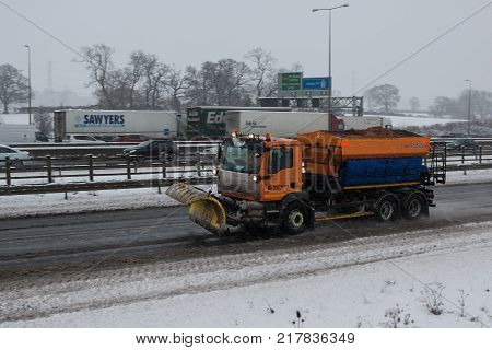 Hemel Hempstead UK - December 10 2017: Snow plough truck spreading salt on the british motorway m1 during snowstorm
