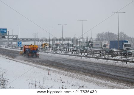 Hemel Hempstead UK - December 10 2017: Snow plough truck spreading salt on the british motorway m1 during snowstorm