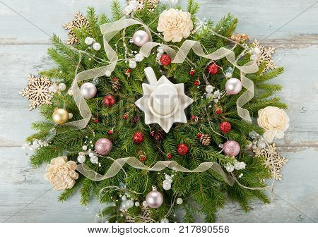 Decorated Advent wreath with white candles on blue wooden background useful as christmas decoration
