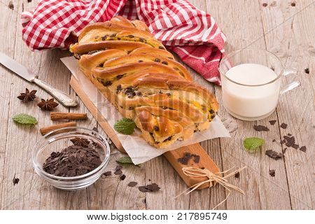 Brioche with chocolate chips on wooden table.