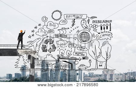 Businessman in helmet drawing eco-analytical strategy while standing on broken bridge with cityscape on background. 3D rendering.