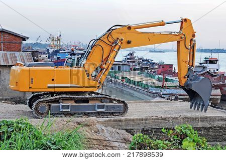 photo of excavator beside the river for shipment