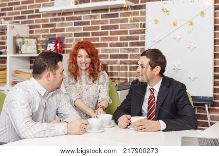 Tea time in the office. Colleagues having tea and chatting in the break enjoying each other.
