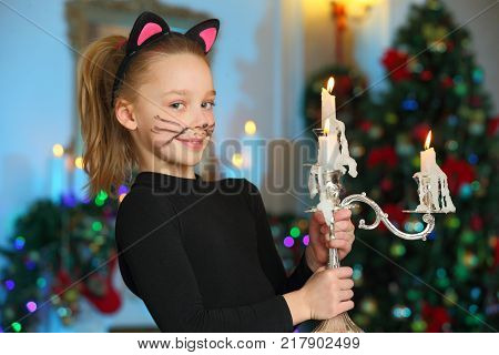 Pretty charming beautiful artistic blond baby girl in Christmas costumes. Beautiful blonde child girl in a carnival costume of a cat.