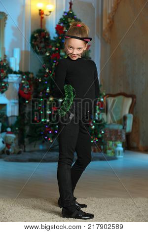 Pretty charming beautiful artistic blond baby girl in Christmas costumes. Beautiful blonde child girl in a carnival costume of a cat.