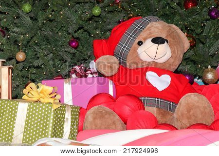 Big Teddy Bear Near A New Year Tree And Gifts