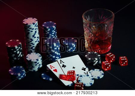Poker cards with cubes are beautifully placed on the table, against the background of poker chips. Still life. The concept of gambling. Poker Online. Cards - two aces