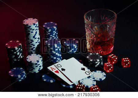 Poker cards with cubes are beautifully placed on the table, against the background of poker chips. Still life. The concept of gambling. Poker Online. Cards - ace and ten