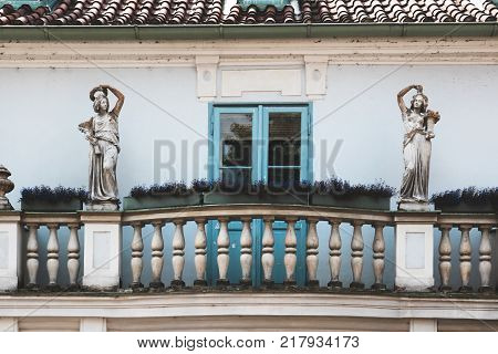 Facade vintage houses with balconies flowers and statues