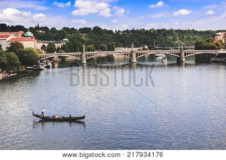 Lonely boat floating with people on the river in the background the bridge and the ships