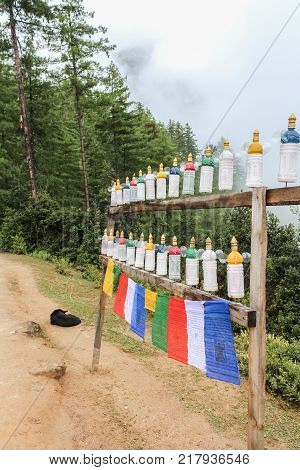 White plastic roadside prayer wheels on the way to Taktshang Palphug Monastery (the Tiger's Nest) Bhutan Asia