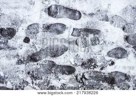 Dirty footprints in the snow in the winter.
