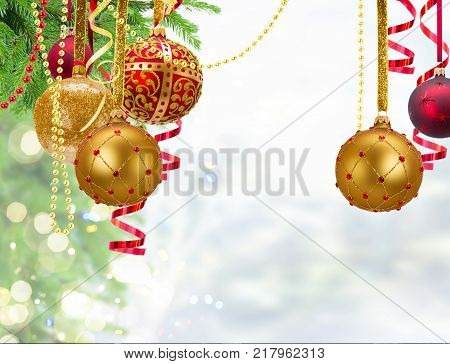 Red and golden christmas balls and evergreen fir tree on blue pale winter background