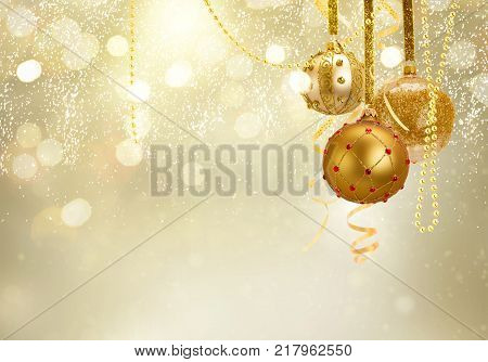Golden christmas balls garland and evergreen fir tree on glowing golden background with copy space