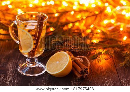 easonal and holidays concept. Christmas and autumn theme. One glasses mulled wine on a rustic wooden table. Selective focus