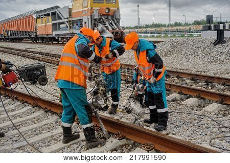 Tobolsk, Russia - July 15. 2016: Sibur company. Denisovka railway station. Railway workers repairing rail in rainy weather