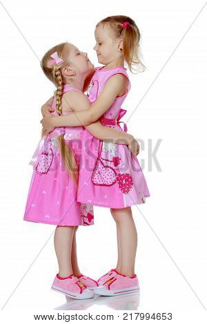 Two little girls hug. The concept of a family happiness, childhood, parenting.isolated on a white background.